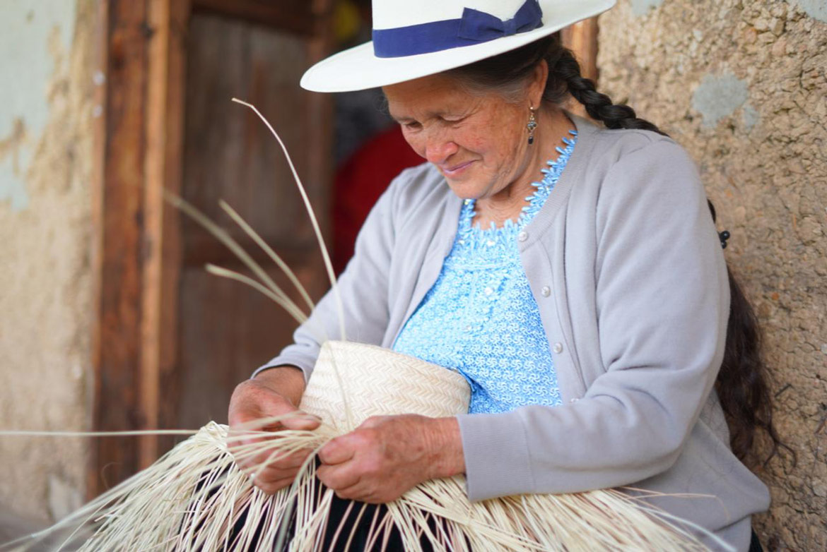 lady weaving paja toquilla into a hat